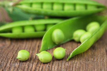 Fresh green peas on wooden table