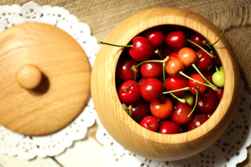 Sweet cherries in bowl on wooden table