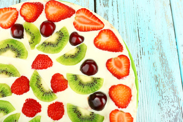 Homemade sweet pizza with fruits on wooden table, close up
