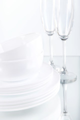 Set of white dishes on table on light background
