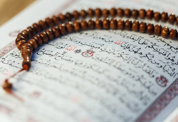 The arabic teхt in the Quran -(holy book of Islam) with rosary (beads)