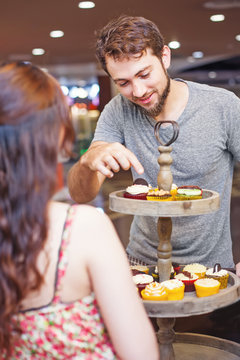 Customer chosing cupcakes in the shop