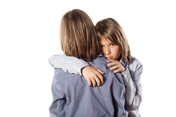 sad boy hugging his twin brother