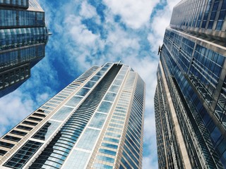 Skyscrapers against cloudy blue sky low angle