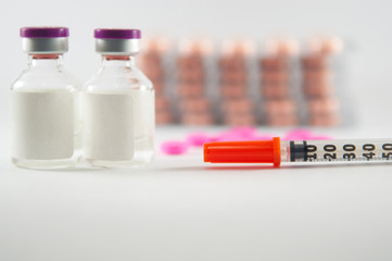 Injection vials and syringe on medicine background