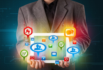 Businessman presenting modern tablet with colorful social signs