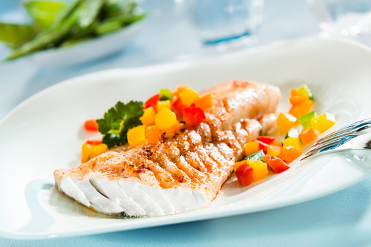 Grilled fish fillet with a colorful fresh salad