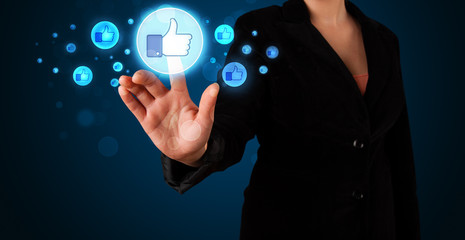 Young businesswoman pressing thumbs up button on modern social n