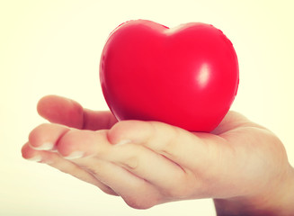 Obraz premium Red heart held on a female's hand.