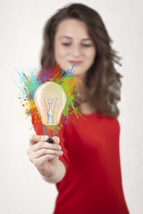 Young lady drawing a colorful light bulb with colorful splashes