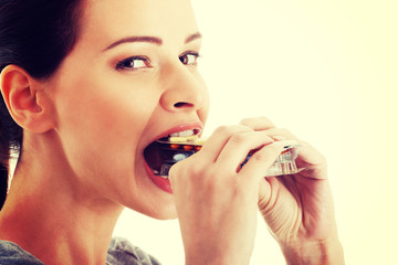 Woman trying to eat blister of pills.