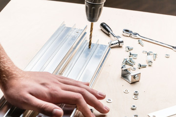 Handwerker bohrt in Aluminiumprofil