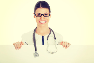 Young female doctor holding copy space.