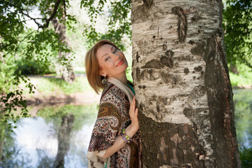 beautiful woman at a tree in summer
