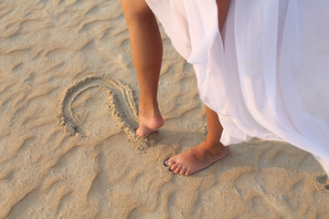 leg girl draws in the sand heart
