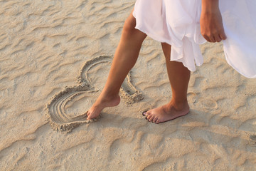 leg girl draws in the sand heart