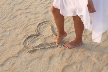 leg girl draws in the sand heart