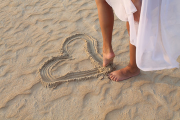 leg girl draws in the sand heart