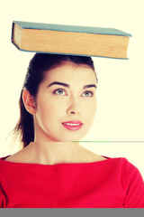 Young caucasian woman with book on her head