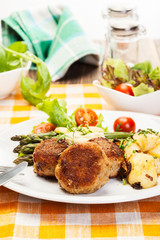 Meatballs served with boiled potatoes and asparagus