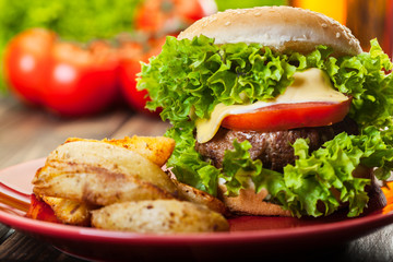 Closeup of cheeseburger with fries potatoes