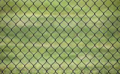 Metal fence with Green grass field background for protection