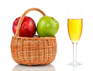 Basket of ripe apples and glass of apple juice