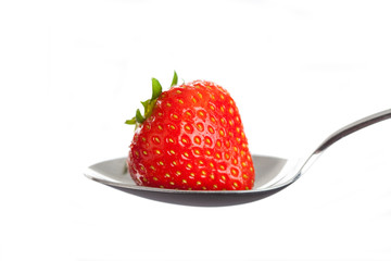 Red strawberry on spoon. Isolated on white