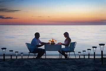 A young couple share a romantic dinner with candles