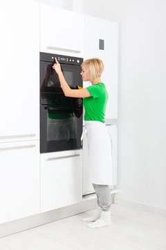 woman press button modern kitchen appliance