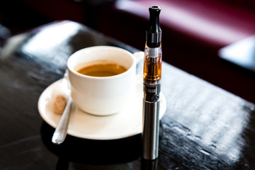 E-cigarette with a cup of filter coffee