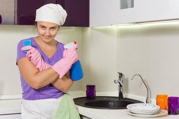 Lady holding spray cleaner and kitchen sponge