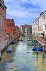Venice canal with gondolas, boats and small bridge. Italy