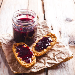black currant jam in glass jar and crackers