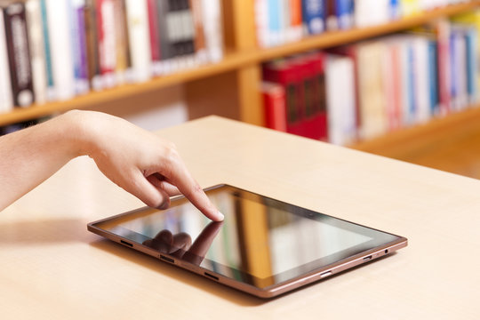 Hand typing on tablet pc in library