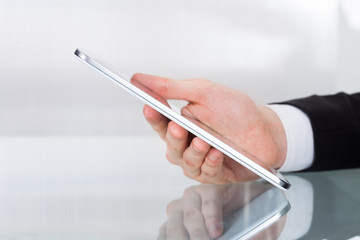 Businessman Holding Digital Tablet At Desk