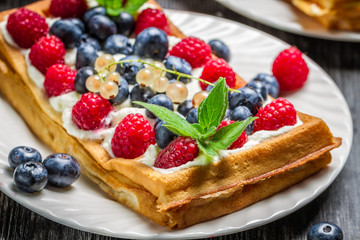 Closeup of waffels with cream and berry fruits