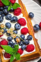 Closeup of waffels with cream and berry fruits