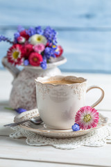 Obraz na płótnie Canvas Closeup of daisy flowers and cup of coffee