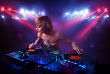 Teenager Dj mixing records in front of a crowd on stage