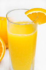 Orange juice in a glass isolated on white wooden background