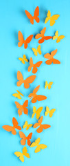 Paper butterflies on blue wooden board background