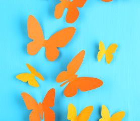 Paper butterflies on blue wooden board background