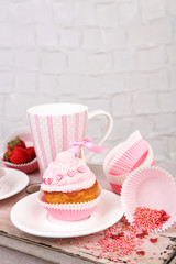 Tasty cup cake with cream on wooden table