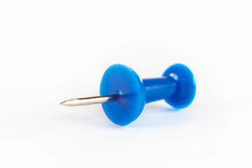 Blue pushpin on the white paper close up