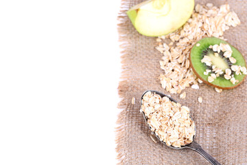 Apple, kiwi fruit with oatmeal and vintage spoon isolated