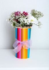 Beautiful flowers in colorful pencils vase in interior design