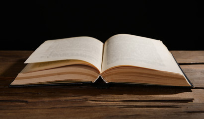 Old book on table on black background