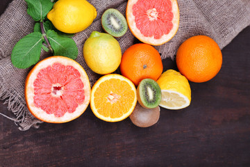 Fresh exotic fruits with green leaves on color wooden