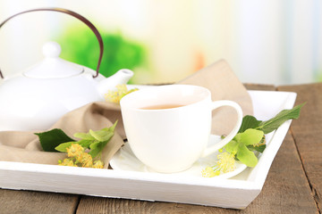 Tasty herbal tea with linden flowers on wooden table